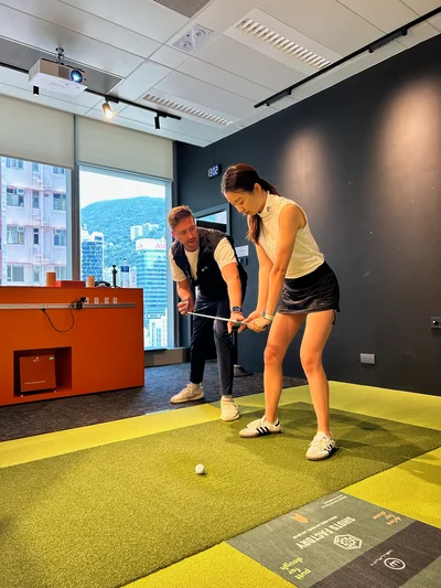 Mike Bygrave coaching during an indoor golf lesson