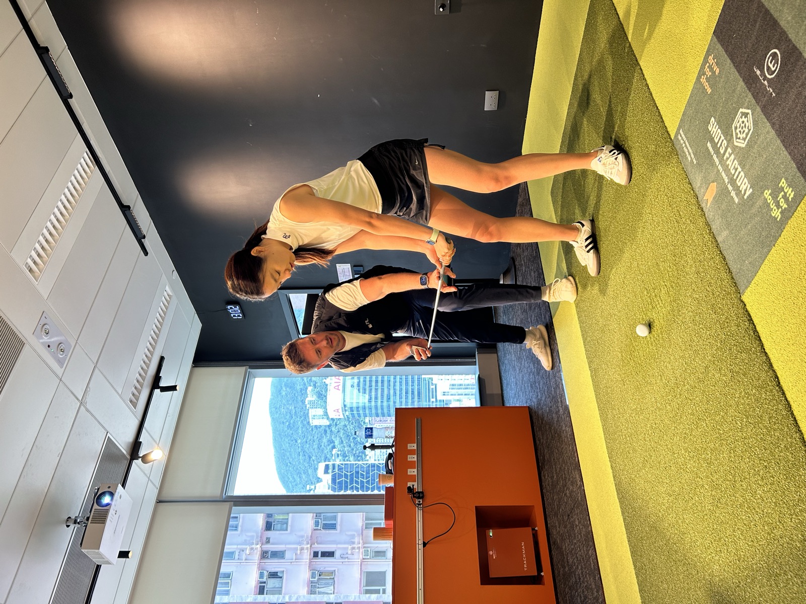Mike Bygrave coaching a golfer's address position at Shots Factory Wanchai
