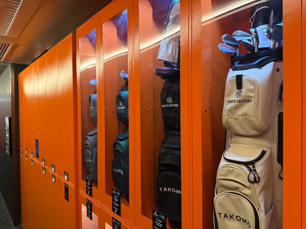 Member golf bags stored in the orange lockers at Shots Factory Wanchai