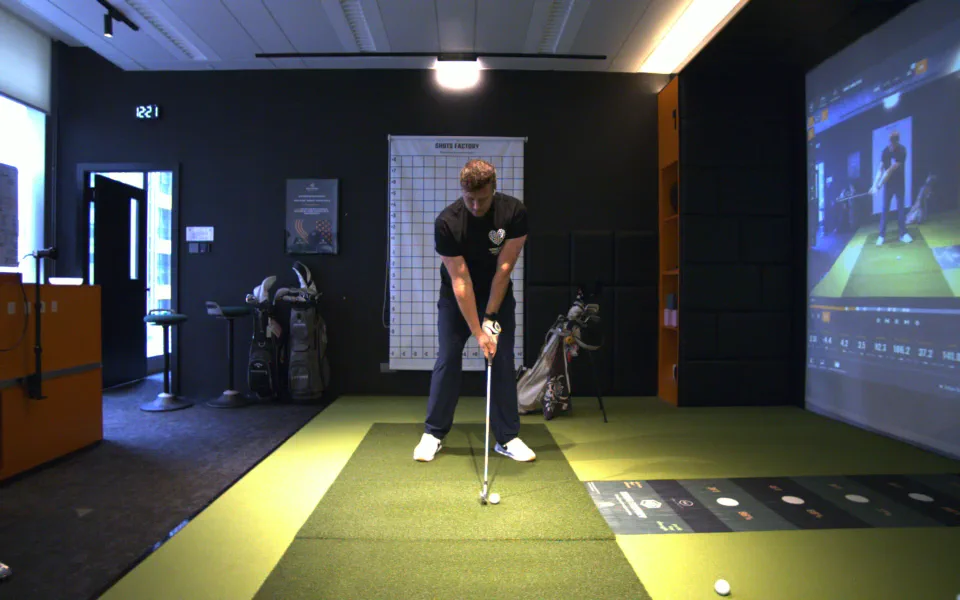 A golfer at address before beginning a full golf swing